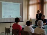 Prelegentka z Komendy Powiatowej Policji w Bielsku Podlaskim omawia slajd z prezentacji multimedialnej dotyczącej zagadnień przeciwdziałania przemocy domowej.