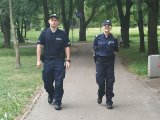 Policjanci patrolują teren parku miejskiego.