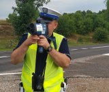 policjant mierzy prędkość pojazdów za pomocą urządzenia pomiarowego