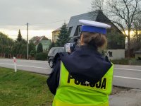 Policjantka mierzy prędkość pojazdów na drodze