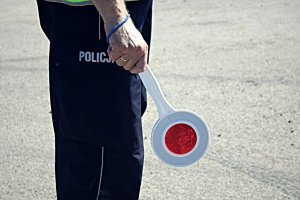 Policjant trzyma tarczkę do zatrzymywania poajzdów