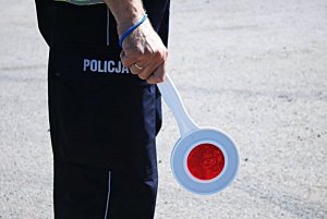 Policjant trzyma tarczkę do zatrzymywania pojazdów