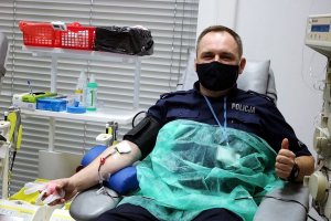 Policjant siedzi na fotelu w punkcie krwiodawstwa