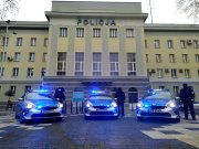 Trzy radiowozy stoją przed budynkiem Komendy Wojewódzkiej Policji w Białymstoku.
