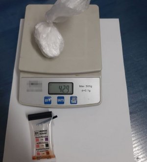 Amfetamina w torebce foliowej leży na wadze, poniżej narkotester