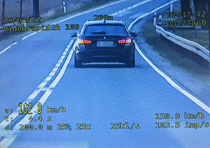 Obraz z kamery videorejestratora, na którym widać samochod jadący ulica.