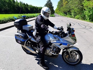 Policjant w mundurze na motocyklu.