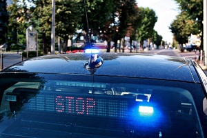 Policyjny samochód z wyświetlonym napisem STOP.