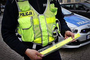 Policjant trzyma opaski odblaskowe