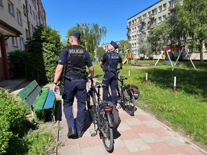 Dwóch umundurowanych policjantów z rowerami sprawdza rejon osiedla