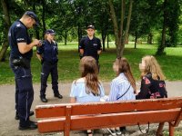 Policjanci legitymują nieletnich w parku miejskim.
