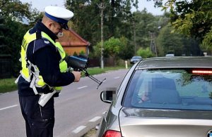 Policjanct pokazuje kierowcy predkość jego samochodu na mierniku prędkości