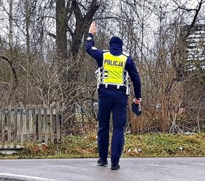 Policjant podnosi rękę do góry