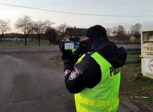 Policjant trzyma ręczny miernik prędkości