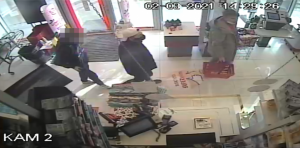 Zdjęcie z monitoringu sklepowego, na którym widać trzech mężczyzn.