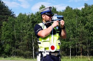 Policjant w mundurze stoi na świeżym powietrzu.