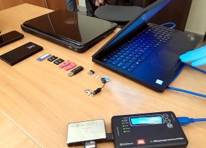 2 laptopy, kary SIM, peindrivy leżą na biurku.