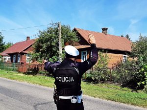 Policjant podnosi rękę i zatrzymuje poajzd