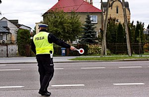Policjant stoi na drodze.