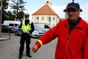 Pan stoi, za nim stoi policjant.