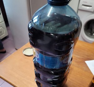 Butelka plastikowa z zawartościa ciemnej cieczy.