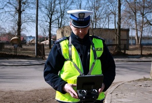 Policjant w mundurze stoi na świeżym powietrzu.