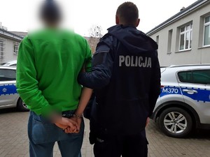 policjant prowadzi zatrzymanego