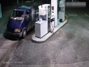 Widok z kamery na stację benzynową, stoi samochód i dystrybutor.