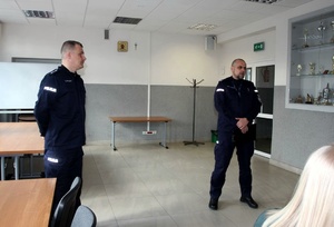 Policjani stoja w budynku.