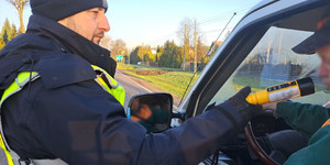 Policjant bada stan trzeźwości kierowcy.