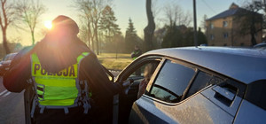 Policjant bada stan trzeźwości kierowcy.