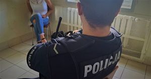 Policjant pilnuje w pomieszczeniu zatrzymanej