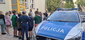 Policjanci rozmawiają z dziećmi o bezpieczeństwie na drodze.