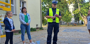 Policjanci rozmawiają z dziećmi o bezpieczeństwie na drodze.