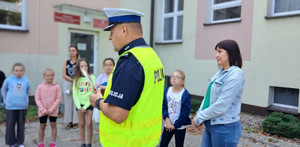 Policjanci rozmawiają z dziećmi o bezpieczeństwie na drodze.
