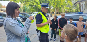 Policjanci rozmawiają z dziećmi o bezpieczeństwie na drodze.