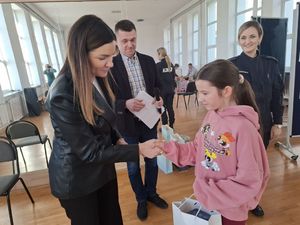 Policjanci wręczają nagrody laureatom konkursu plastycznego.