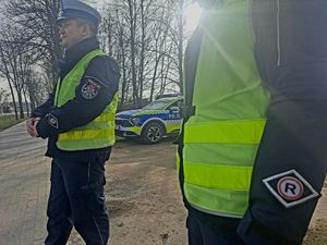 Policjanci stoją przy drodze.