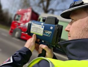 Policjant mierzy prędkość pojazdów.