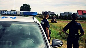 Policjantki i radiowóz stoją.