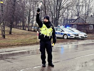 Policjant podnosi tarczkę do góry.