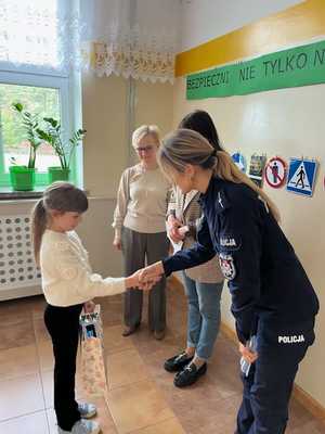 Policjanci wręczają nagrody w konkursie plastycznym.