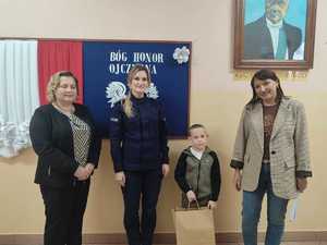 Policjanci wręczają nagrody w konkursie plastycznym.