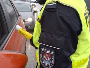 Policjant trzyma ręczny miernik prędkości.