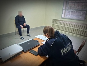 Policjantka przesłuchuje zatrzymanego mężczyznę.