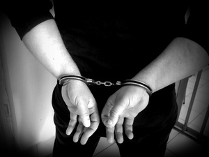 Kajdanki założone na ręce osoby.