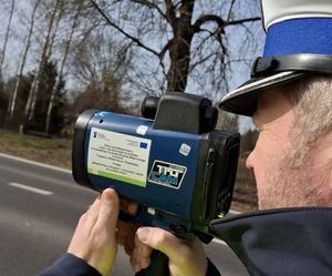 Policjant mierzy prędkośc urządzeniem.