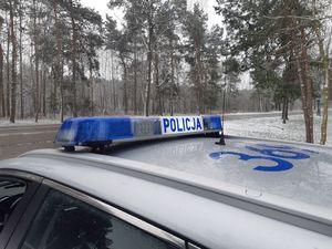 Radiowóz stoi zimą przy drodze.