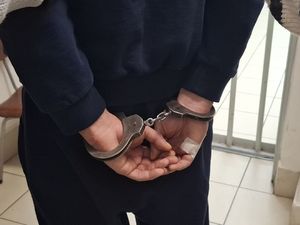 Policjanci wykonują czynności z zatrzymanym mężczyzną.