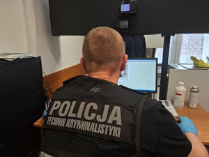 Policjanci wykonują czynności z zatrzymanym mężczyzną.